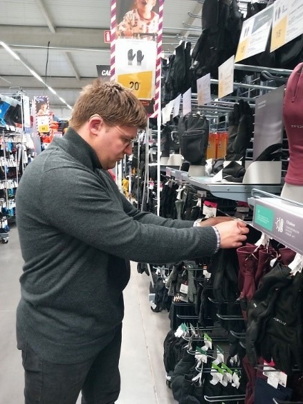 Un travailleur d'ESAT met en rayon des produits de Décathlon.